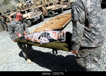 Apr 18, 2008 - La province de Paktya, Afghanistan - l'un des deux chauffeurs de camions Afghans blessés lors d'une embuscade d'insurgés conçu pour détourner les camions et les mettre en feu est assisté par Jean Giasullo PFC infirmier de l'armée à la base d'opérations avancée désert, l'Est de l'Afghanistan. L'Aghan est fixé sur un Gator pour Banque D'Images