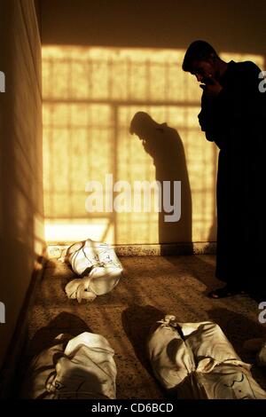 28 mai 2003 - Al-Musayab, Iraq - Un homme regarde à l'Iraq demeure enveloppé d'organes d'un charnier dans le désert près de Al-Musayab, de l'Iraq. Les corps sont exposés dans une ancienne salle de sport, abrite maintenant le groupe local de défense des droits humains qui est l'exhumation de la tombe. Les gens viennent de partout pour Banque D'Images
