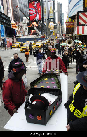 Times Square pleure la mort de l'hiver et accueille le printemps avec une nouvelle Orleans - jazz style funérailles. En deuil, ornée de fleurs et de chapeaux colorés, parapluies et ceinturons suivre la procession avec 'porteurs' portant un mock coffin transportant un bonhomme à son dernier lieu de repos. Banque D'Images