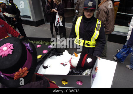 Times Square pleure la mort de l'hiver et accueille le printemps avec une nouvelle Orleans - jazz style funérailles. En deuil, ornée de fleurs et de chapeaux colorés, parapluies et ceinturons suivre la procession avec 'porteurs' portant un mock coffin transportant un bonhomme à son dernier lieu de repos. Banque D'Images