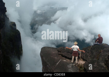 21 avr 2008 - Canaima, Venezuela - en et au-dessus des nuages, American Ben Ballweg, à gauche, et l'Italien Roberto Aquila parler de l'immense taille du mont à proximité Canaima, assis sur des rochers avec une goutte de centaines de mètres au sommet du mont Roraima, un 2 810 mètres de haut situé dans le sud de la montagne Venezu Banque D'Images