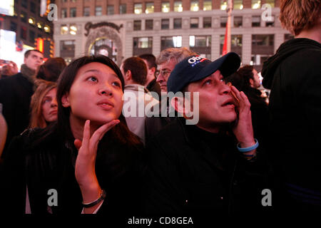 Nov 04, 2008 - Manhattan, New York, USA - JENNIFER FENG, 25 ans, de Manhattan, à gauche, et EDWIN APARICIO, 40, de Washington Heights, New York, et retenir ses larmes en regardant Obama donner son discours. Spectateurs regarder le écrans géants de Times Square, qui voient les résultats des élections en temps réel i Banque D'Images