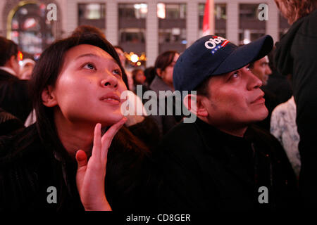 Nov 04, 2008 - Manhattan, New York, USA - JENNIFER FENG, 25 ans, de Manhattan, à gauche, et EDWIN APARICIO, 40, de Washington Heights, New York, et retenir ses larmes en regardant Obama donner son discours. Spectateurs regarder le écrans géants de Times Square, qui voient les résultats des élections en temps réel i Banque D'Images