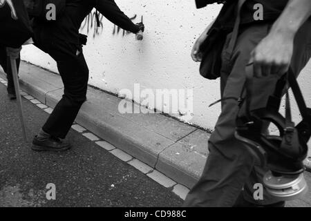 Jun 25, 2010 - Toronto, Ontario, Canada - Black bloc protestataire dessine un graffiti sur le mur pendant le Sommet du G20 de protestation. Ce manifestants sont bien préparés à l'affrontement avec la police avec leur masque à gaz lacrymogène et bouts de bois.. Bien que la réunion du G20 s'est passé à Toronto le juin 2010, le Black Bloc a pris à Banque D'Images