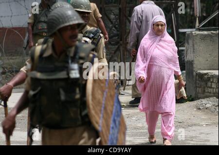 Jul 28, 2010 - Cachemire, Srinagar, Inde - les femmes musulmanes du Cachemire indien marche comme soldats paramilitaires montent la garde lors d'une manifestation anti-Inde à Srinagar, la capitale d'été du Cachemire indien. Depuis le 11 juin cette année, 17 personnes sont mortes et des décès sont attribués aux forces de sécurité indiennes pendant les semaines de Banque D'Images