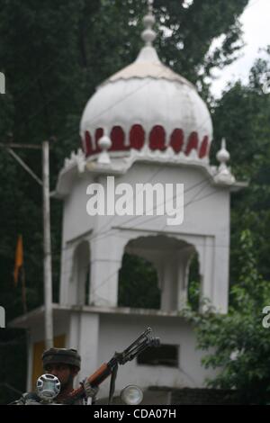 29 juil., 2010 - Srinagar, au Cachemire, l'Inde - Indian des soldats montent la garde au cours d'une manifestation sur la route nationale. Les Sikhs manifestaient contre l'enrôlement forcé de couper les cheveux d'un garçon sikh en Afrique du Cachemire ville de tral par certaines personnes non identifiées. Couper des cheveux est considérée comme un péché dans la religion Sikh. ( Banque D'Images