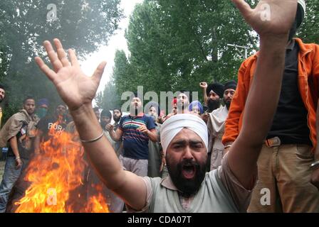 29 juil., 2010 - Srinagar, au Cachemire, en Inde - Cachemire Sikhs crier des slogans à côté d'un feu de joie au cours d'une manifestation sur la route nationale. Les Sikhs manifestaient contre l'enrôlement forcé de couper les cheveux d'un garçon sikh en Afrique du Cachemire ville de tral par certaines personnes non identifiées. Couper des cheveux est considérée comme un péché Banque D'Images