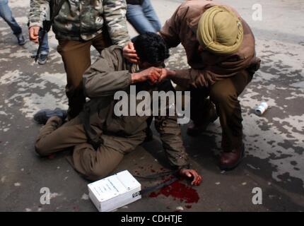 11 févr. 2011 - Srinagar, au Cachemire, l'Inde - Indian policiers portant leur collègue qui a été blessé lors d'un affrontement marquer le 27e anniversaire de la mort du Jammu-et-Cachemire (JKLF) avant de la libration fondateur Maqbool Bhat dans la capitale d'été du Cachemire indien. Dirigeants et partisans du cachemire seperatist call Banque D'Images