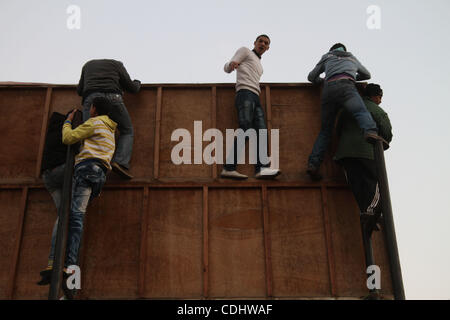 Feb 11, 2011 - Le Caire, Egypte - Garçons monter un panneau publicitaire pour regarder le coucher du soleil des prières. Les manifestants se sont réunis dans Anti-Mubarak Al-Tahri square après que le président a prononcé un discours jeudi soir, déclarant qu'il n'aurait pas démissionner. Plus tard dans la journée, Moubarak a remis le pouvoir à l'armée. (Ima Crédit Banque D'Images