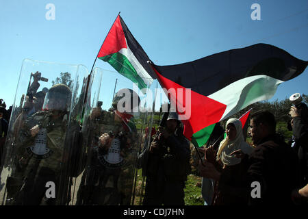 Des soldats israéliens échauffourée avec les manifestants palestiniens au cours de la manifestation hebdomadaire contre le mur de séparation dans le village cisjordanien de Bil'in près de Ramallah, Vendredi 18 Février, 2011. Photo par Issam Rimawi Banque D'Images