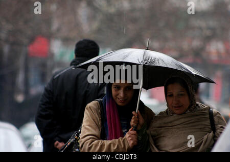 Une femme musulmane du cachemire à pied pendant chute de pluie à Srinagar, la capitale d'été du Cachemire indien le 24/2/2011, l'autoroute nationale stratégique Srinagar-Jammu Jeudi a été fermée à la circulation en raison des glissements de terrain à certains endroits et des routes glissantes.'Nous avons dégagé les véhicules échoués sur le Banque D'Images