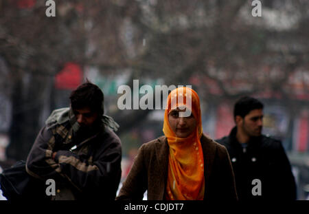 Une femme musulmane du cachemire à pied pendant chute de pluie à Srinagar, la capitale d'été du Cachemire indien le 24/2/2011, l'autoroute nationale stratégique Srinagar-Jammu Jeudi a été fermée à la circulation en raison des glissements de terrain à certains endroits et des routes glissantes.'Nous avons dégagé les véhicules échoués sur le Banque D'Images