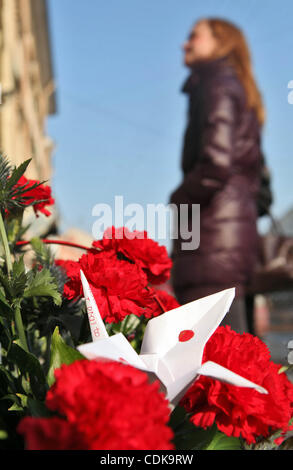 14 Mar 2011 - St Petersburg, Russie - russe's express deuil catastrophe au Japon. Peuple russe portant des fleurs et grue de papier avec drapeau japonais au consulat japonais à Saint-Pétersbourg, en mémoire des victimes du tremblement de terre, tsunami au Japon. Un énorme, puissant et mortel 8. Banque D'Images