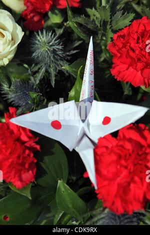 Deuil express russes catastrophe au Japon. Peuple russe portant des fleurs au consulat japonais de Saint-Pétersbourg à la mémoire des victimes de la catastrophe au Japon.Photo : fleurs et grues de papier avec drapeau japonais . Banque D'Images