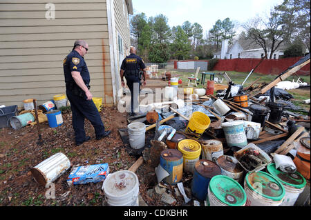 Mar. 15, 2011 - Lawrenceville, Géorgie, États-Unis - Le Sgt. Greg chapelle (L) et sous-L. Dozier avec le bureau du shérif du comté de Gwinnett cour civile, division de marche autour de objets mis au rebut dans l'arrière-cour d'une maison abandonnée pendant l'application de la forclusion à Lawrenceville, Georgia USA le 25 février 2011. L Banque D'Images