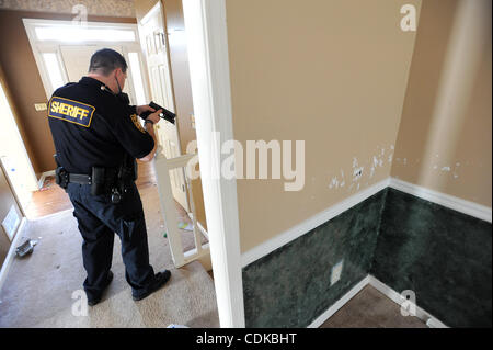 Mar. 15, 2011 - Lawrenceville, Géorgie, États-Unis - Sous-Alan Shippey avec le Gwinnett County Sheriff's Office, division de la cour civile vérifie soigneusement un bien pour personne alors qu'une expulsion de forclusion de Lawrenceville, Georgia USA le 25 février 2011. Le Bureau du shérif du comté de Gwinnett a Banque D'Images