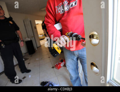 Mar. 15, 2011 - Lawrenceville, Géorgie, États-Unis - Le Sgt. Greg Chapelle avec le bureau du shérif du comté de Gwinnett cour civile division, observe alors que les verrous sont rapidement changé à une maison tout en servant une forclusion à Lawrenceville, Georgia USA le 25 février 2011. Le shérif du comté de Gwinnett O Banque D'Images