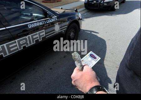 Mar. 15, 2011 - Norcross, Georgie, États-Unis - Le Sgt. Greg Chapelle avec la Gwinnett County Sheriff's Office, division de la cour civile détient le permis de conduire et un sac de marijuana résident après Maurice Adams a été arrêté pour avoir prétendument l'objet d'un mandat et la possession de marijuana, tandis que servin Banque D'Images