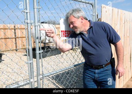 Le 17 mars 2011 - Weatherford, Texas, USA - 3/17/2011. Tim Ruggerio rappelle les mouvements de la caméra qui filme la zone autour du puits de pétrole d'Aruba sur sa propriété près de Decatur, Texas. Même avec la barrière et aucune intrusion des signes, le verrou sur la porte est déverrouillée. La qualité de l'air Banque D'Images