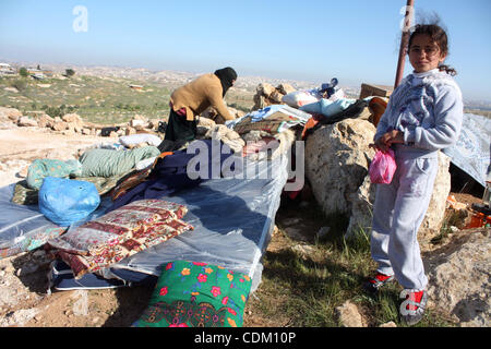 Famille palestinienne rechercher d'effets personnels dans les décombres de leur maison après qu'il a été détruit par des tracteurs de l'armée israélienne début le 29 mars 2011, dans le village de Yatta, près d'Hébron. La maison était située dans la zone C, une zone militaire fermée où Israël exerce pleine cont Banque D'Images