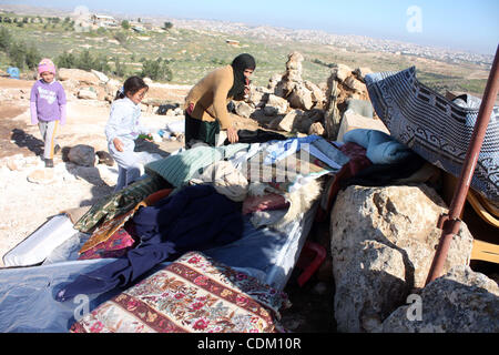 Famille palestinienne rechercher d'effets personnels dans les décombres de leur maison après qu'il a été détruit par des tracteurs de l'armée israélienne début le 29 mars 2011, dans le village de Yatta, près d'Hébron. La maison était située dans la zone C, une zone militaire fermée où Israël exerce pleine cont Banque D'Images