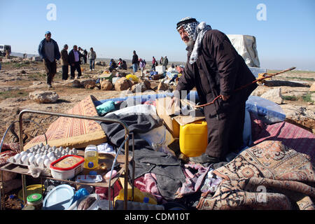 Famille palestinienne rechercher d'effets personnels dans les décombres de leur maison après qu'il a été détruit par des tracteurs de l'armée israélienne début le 29 mars 2011, dans le village de Yatta, près d'Hébron. La maison était située dans la zone C, une zone militaire fermée où Israël exerce pleine cont Banque D'Images