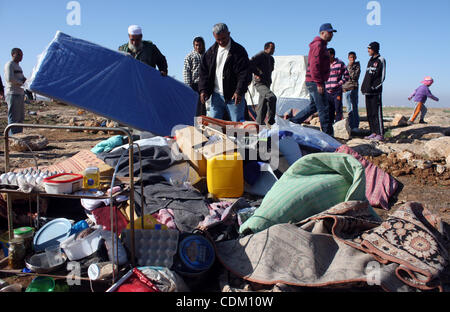 Famille palestinienne rechercher d'effets personnels dans les décombres de leur maison après qu'il a été détruit par des tracteurs de l'armée israélienne début le 29 mars 2011, dans le village de Yatta, près d'Hébron. La maison était située dans la zone C, une zone militaire fermée où Israël exerce pleine cont Banque D'Images