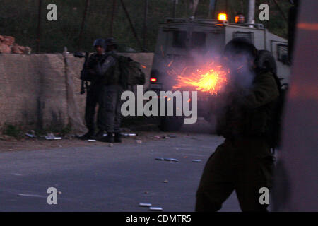 Des soldats israéliens fire des gaz lacrymogènes en direction des jeunes Palestiniens à la périphérie de la ville de Ramallah, en Cisjordanie, le Jeudi, Avril 14, 2011. Selon l'armée palestiniens ont lancé des pierres sur des soldats israéliens au cours d'une opération de routine dans la région. Selon des sources palestiniennes, 2 hommes ont été arrêtés à l'affrontement. Banque D'Images