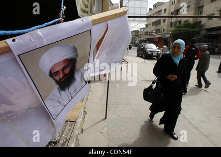 Les Palestiniens passent devant une affiche d'Oussama ben Laden, dans le sud de la bande de Gaza ville de Rafah le 2 mai 2011. Les États-Unis ont tué le chef d'Al-Qaïda Oussama ben Laden près de 10 ans après les attentats du 11 septembre 2001, le président américain Barack Obama a déclaré dans un discours télévisé. Photo par Abe Banque D'Images