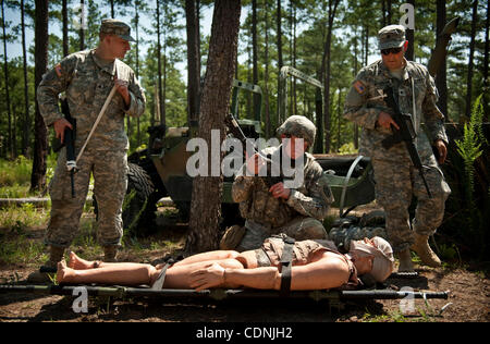 14 juin 2011 - Fort Bragg, Caroline du Nord, États-Unis - SPC. DAVID KERR, de gauche à droite, le s.. THOMAS SAGER et SPC. CHRISTOPHER ROBINSON regarde un mannequin après l'attachant à une civière au cours de l'Army Medical Command a concurrence meilleur guerrier à la simulation médicale Centre de formation. Sager Banque D'Images