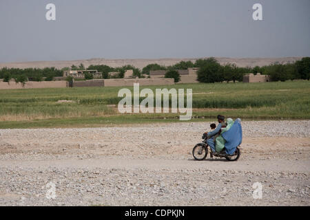 10 mai 2011 - Khatki, province de Helmand, Afghanistan - Un Afghan donne une ride pour un garçon et deux femelles sur une moto près de la ville de Musa Qala dans le district de Musa Qala dans la province d'Helmand, en Afghanistan. Le but de l'opération Rocky Point était de perturber le commerce de l'opium à l'un des bazars en th Banque D'Images