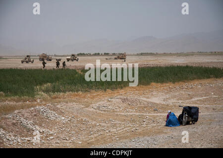 10 mai 2011 - Khatki, province de Helmand, Afghanistan - Un homme et une femme afghane attendre près de leur motocyclette comme Marines des États-Unis du 3e bataillon du 2e Régiment de Marines pousser vers eux au cours de l'opération Rocky Point dans la ville de Musa Qala dans Khatki district dans la province de Helmand, en Afghanistan. Le but o Banque D'Images