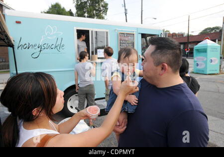 13 juillet 2011 - Atlanta, GA, États-Unis - ATLANTA, GA - 13 juillet : Emery Peng, tenu par son père, Ray Gelato est alimenté certains par sa mère Ashley de l'Honeysuckle camion alimentaire dans un parking dans le quartier Virginia-Highland à Atlanta, Géorgie le mercredi, Juillet 13, 2011. Crédit photo : ERIK S. moindre Banque D'Images