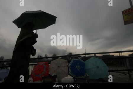 Apr 18, 2011 - Srinagar, au Cachemire, en Inde - Cachemire femmes musulmanes à pied lors de pluies à Srinagar, la capitale d'été du Cachemire indien. De fortes pluies ont fouetté large parties de Jammu-et-Cachemire, forçant la fermeture temporaire de la route nationale reliant l'Srinagar-Jammu valley à reste du pays. K Banque D'Images