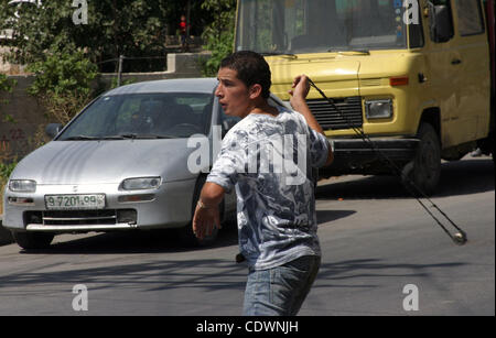 Un manifestant palestinien lance des pierres en direction des soldats israéliens au cours d'une manifestation par des Palestiniens, des Israéliens, et des manifestants dans le village de Beit Omar, près de Hébron, vendredi 22 juillet, 2011. La manifestation en question une récente vidéo diffusée par une organisation israélienne de défense des droits de l'e Banque D'Images