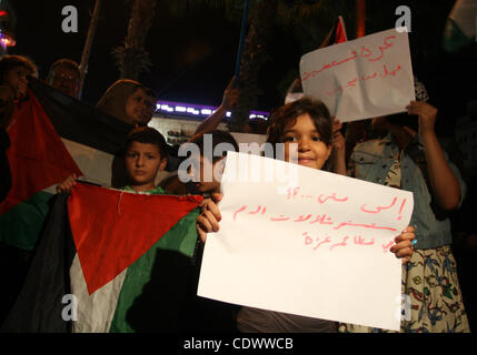 Les Palestiniens avec leur drapeau national et tenir des pancartes au cours d'une manifestation en solidarité avec les habitants de la bande de Gaza, dans la ville de Ramallah, en Cisjordanie sur août 19,2011. Israël a frappé Gaza avec deux jours de bombardements tuant dix militants et deux civils, les enfants âgés de 2 et 13. Photo de est Banque D'Images