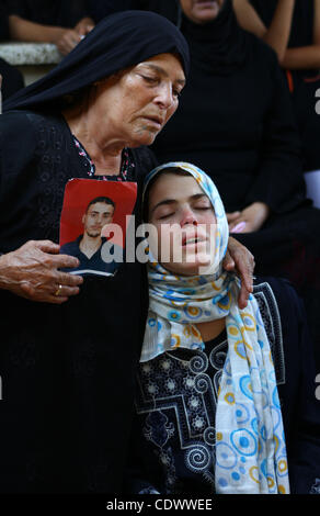 La soeur de militant du Jihad islamique palestinien Anwar Isleem seens (sur la photo) et sa mère pleurent lors de ses funérailles dans le camp de réfugiés de Bureij au centre de la bande de Gaza le 20 août 2011. Anwar Isleem et Emad Abu Aabdeh ont été tués au cours d'un bombardement israélien en réponse aux roquettes militant. P Banque D'Images