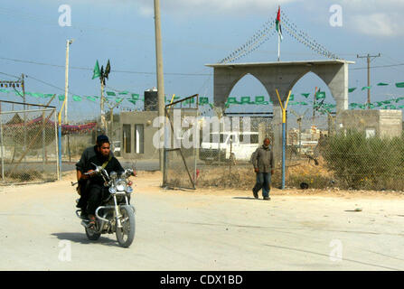 17 octobre 2011 - Rafah, bande de Gaza, territoire palestinien - un partisan du Hamas palestinien se bloque comme décoration drapeaux islamique vert en vue de la prochaine d'échange de prisonniers, à l'entrée de la frontière de Rafah, au sud de la bande de Gaza, le Lundi, Octobre 17, 2011. L'échange entre Israël et le Hamas dans l'étude whi Banque D'Images