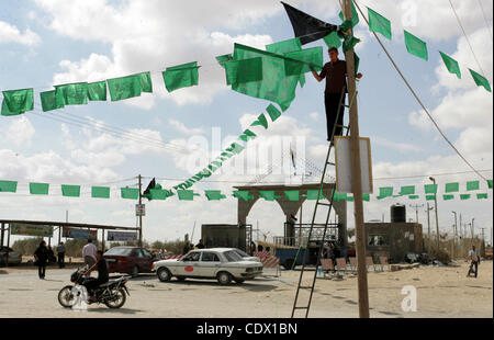 17 octobre 2011 - Rafah, bande de Gaza, territoire palestinien - un partisan du Hamas palestinien se bloque comme décoration drapeaux islamique vert en vue de la prochaine d'échange de prisonniers, à l'entrée de la frontière de Rafah, au sud de la bande de Gaza, le Lundi, Octobre 17, 2011. L'échange entre Israël et le Hamas dans l'étude whi Banque D'Images