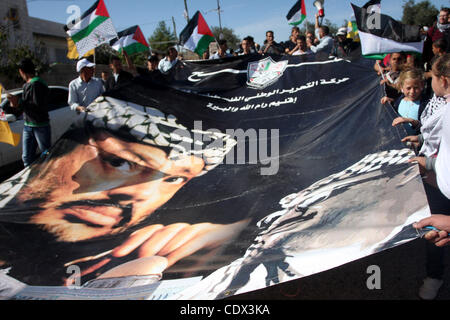 12 novembre 2011 - Ramallah, Cisjordanie, territoire palestinien - des manifestants palestiniens tenir une bannière avec la photo de la fin le président palestinien Yasser Arafat lors d'affrontements entre les forces de sécurité israéliennes et palestiniennes des manifestants lors d'une manifestation hebdomadaire dans le village de Nabi Saleh, n Banque D'Images