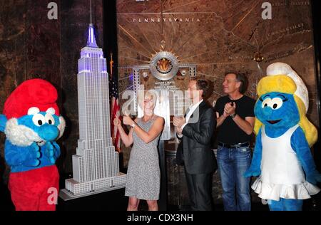 25 juillet 2011 - Manhattan, New York, États-Unis - l'étoile de les Schtroumpfs, Neil Patrick Harris (C) avec Véronique CULLIFORD, la fille de Schtroumpfs Peyo Culliford créateur et directeur RAJA Gosnell, la lumière l'Empire State Building Smurfy bleu pour fêter la sortie du film Les Schtroumpfs en 3D et d'encoura Banque D'Images