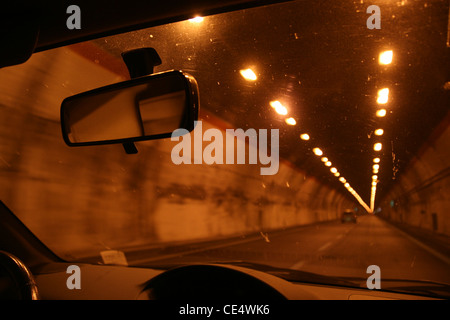 Voiture rapide la conduite en tunnel sombre dans la nuit Banque D'Images