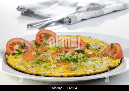 Omelette aux carottes et tomates sur une plaque Banque D'Images