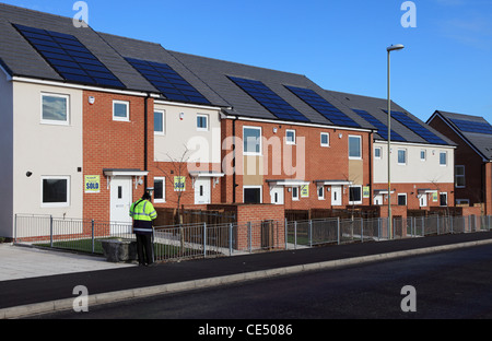 Arpenteur de l'Ordnance Survey mesure la position d'une rue de nouvelles maisons équipées de panneaux solaires en Whitburn, Angleterre du Nord-Est, Royaume-Uni Banque D'Images