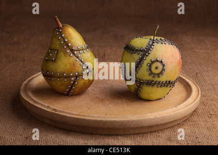 Pomme et poire Fruits manipulés avec ongles tenant ensemble Banque D'Images