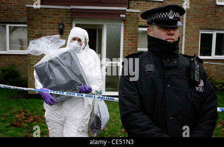 Scène de crime Bureau déposer un ordinateur à partir d'une scène de crime comme un policier monte la garde. Photo par James Boardman. Banque D'Images