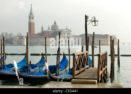 Gondoles accosté à côté de la Place Saint-Marc, Venise, Italie. L'église de San Giorgio Maggiore peut être vu dans la distance. Banque D'Images