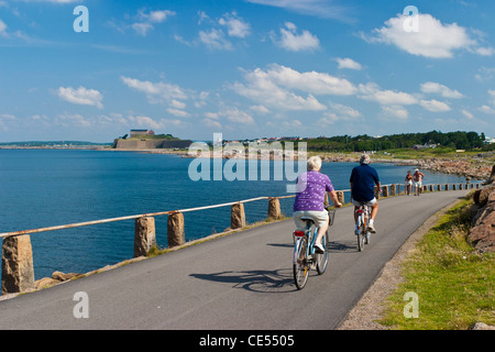 L'homme et la femme à vélo par la mer à Varberg, Suède Banque D'Images