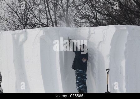 Sculpteur de neige homme travaillant avec un outil électrique. Banque D'Images