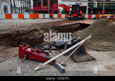 Un marteau pneumatique, digger seau, brosse et niveau mensonge par le côté des travaux de construction pour le nouveau réseau de tramway à Tours, France Banque D'Images